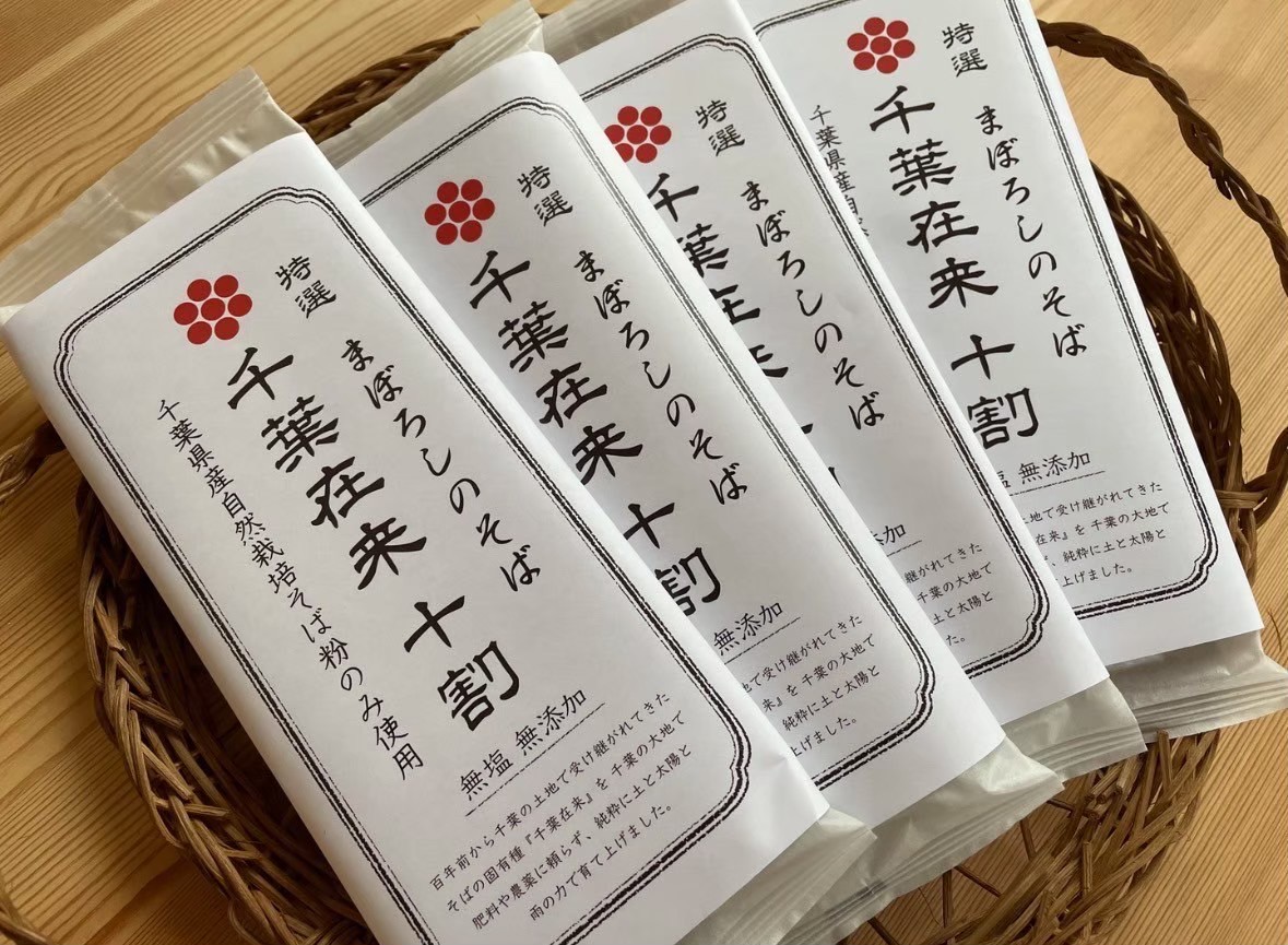 「千葉在来」は、千葉県に古くから根づく在来種。長い年月をかけて土地の気候や土壌に馴染み、他の品種にはない香ばしさと深い甘みを育みます。

この蕎麦には、挽きぐるみの石臼挽き粉を使用。甘皮まで含むことで、香りと栄養が凝縮されています。原材料はそば粉と水のみ。余計なものを足さない潔さが、この蕎麦の美しさです。

若葉区野呂町で脈々と受け継がれる『千葉在来』は、生産者が少なく市場にほとんど出回らないので“幻のそば”とも呼ばれます。『千葉穀物』では、肥料や農薬を使わず自然の力をそのまま活かした栽培方法で、貴重な“種”を守っています。

「この魅力を多くの人に伝えたい」と、誕生したのがこちらの商品。石臼で挽いたそば粉は、甘皮や胚芽を含む栄養豊富な挽きぐるみ。つなぎを加えず水とそば粉のみで贅沢に仕立てました。コシや弾力を感じる食感と、素材本来の豊かな風味は十割そばならでは。濃厚なそば湯も味わい深く、千葉の大地の恵みをたっぷりご堪能いただけます。